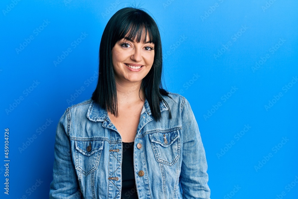 Young hispanic woman wearing casual denim jacket with a happy and cool smile on face. lucky person. Young hispanic woman wearing casual denim jacket with a happy and cool smile on face. lucky person.