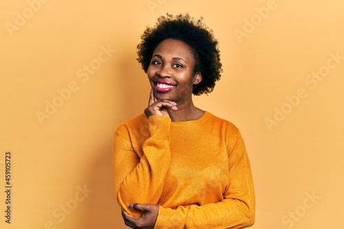 Young african american woman wearing casual clothes looking confident at the camera smiling with crossed arms and hand raised on chin. thinking positive. © Krakenimages.com