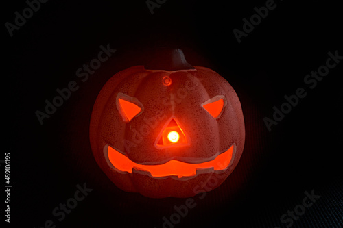 A glowing carved pumpkin in a black background - halloween concept