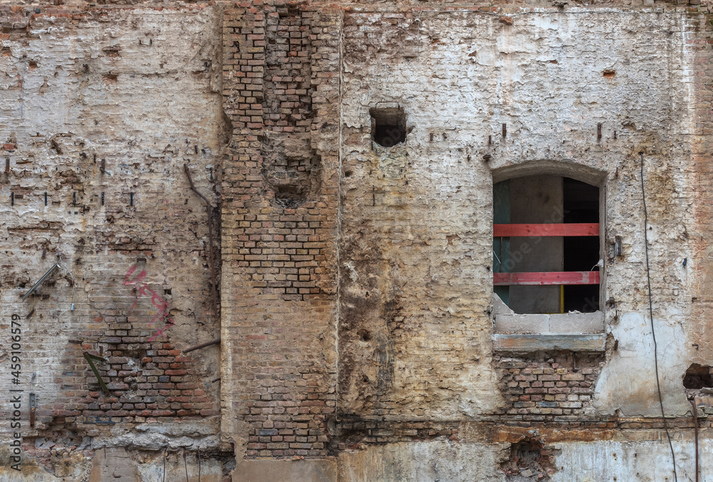 Broken red brick wall and damaged plaster on the background