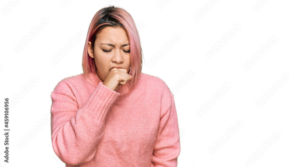 Hispanic woman with pink hair wearing casual winter sweater feeling unwell and coughing as symptom for cold or bronchitis. health care concept. Hispanic woman with pink hair wearing casual winter sweater feeling unwell and coughing as symptom for cold or bronchitis. health care concept.