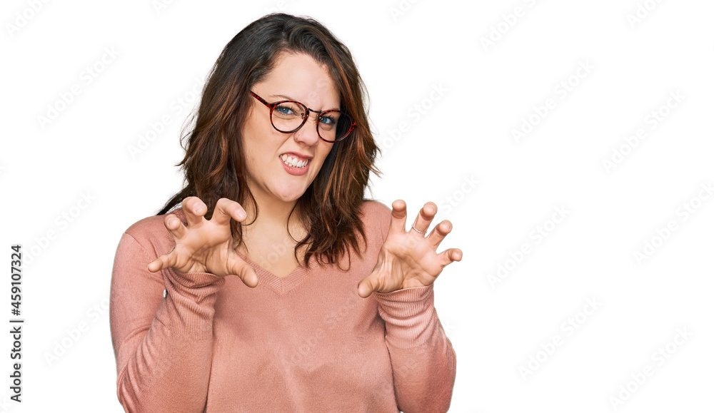 Young plus size woman wearing casual clothes and glasses smiling funny doing claw gesture as cat, aggressive and sexy expression Young plus size woman wearing casual clothes and glasses smiling funny doing claw gesture as cat, aggressive and sexy expression