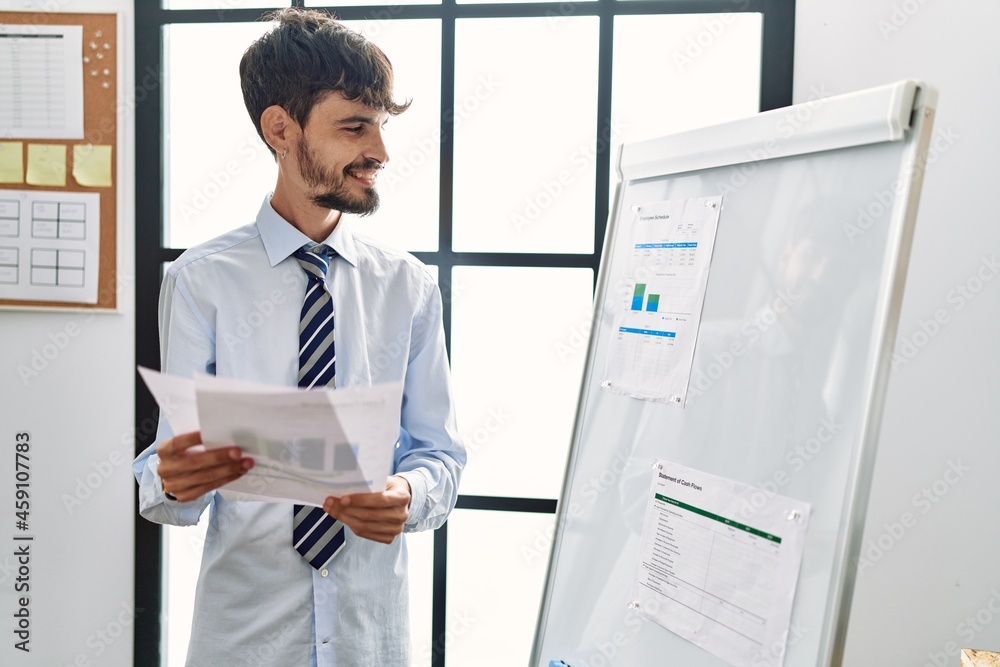 Young hispanic businessman smiling happy working at the office. Young hispanic businessman smiling happy working at the office.