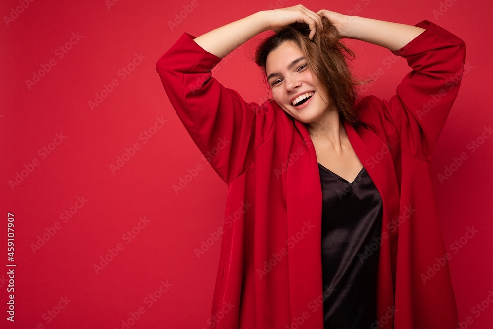 Young beautiful european stylish brunette woman wearing black blouse top and red cardigan isolated over red background with positive sincere emotions. Simple and natural looking at the camera. Free Young beautiful european stylish brunette woman wearing black blouse top and red cardigan isolated over red background with positive sincere emotions. Simple and natural looking at the camera. Free