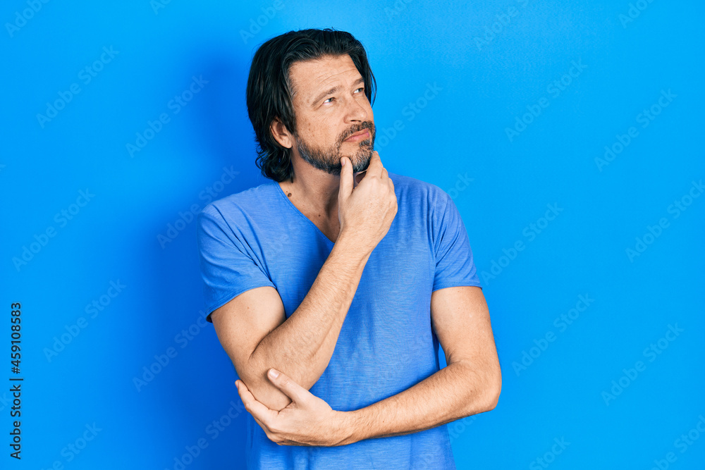 Middle age caucasian man wearing casual clothes with hand on chin thinking about question, pensive expression. smiling with thoughtful face. doubt concept.