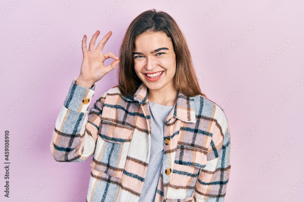 Young caucasian girl wearing casual clothes smiling positive doing ok sign with hand and fingers. successful expression. Young caucasian girl wearing casual clothes smiling positive doing ok sign with hand and fingers. successful expression.