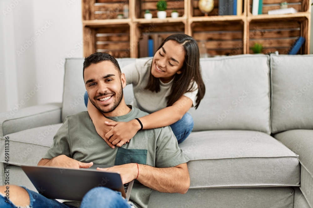 Young latin couple smiling happy using laptop at home. Young latin couple smiling happy using laptop at home.