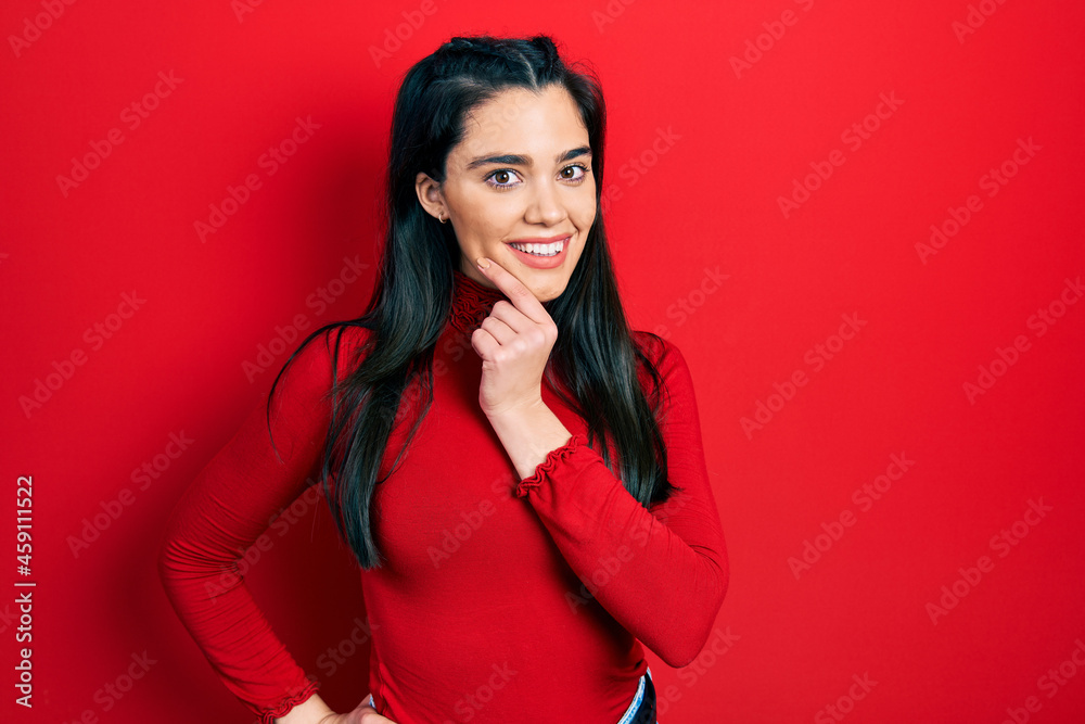 Young hispanic girl wearing casual clothes smiling looking confident at the camera with crossed arms and hand on chin. thinking positive.