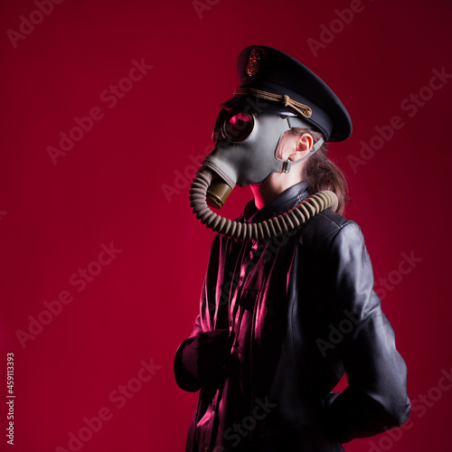 fantastic Nazi in black leather clothes and a cap with a gas mask on face, photo