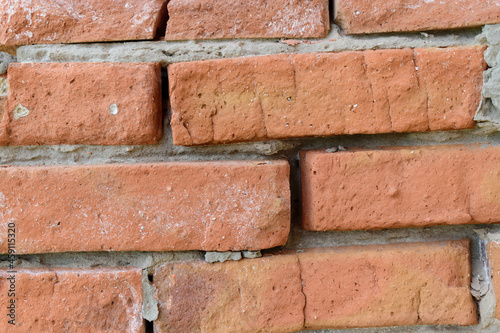 Brick wall close-up. Red brickwork with concrete joints.