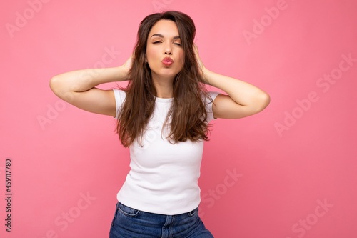 Photo shot of cute nice charming gorgeous attractive pretty youngster happy woman wearing white t-shirt for mockup isolated over colorful background with copy space and giving kiss