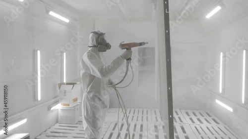 Powder coating of metal products. Industrial painting metal powder coating paint manufacturing process. Coveralls worker with spray gun painting parts metal workshop. Metalwork workpiece factory paint