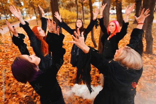Coven of witches, a group of friends as witches on Halloween perform a ritual, lead a round dance and recite spells. photo