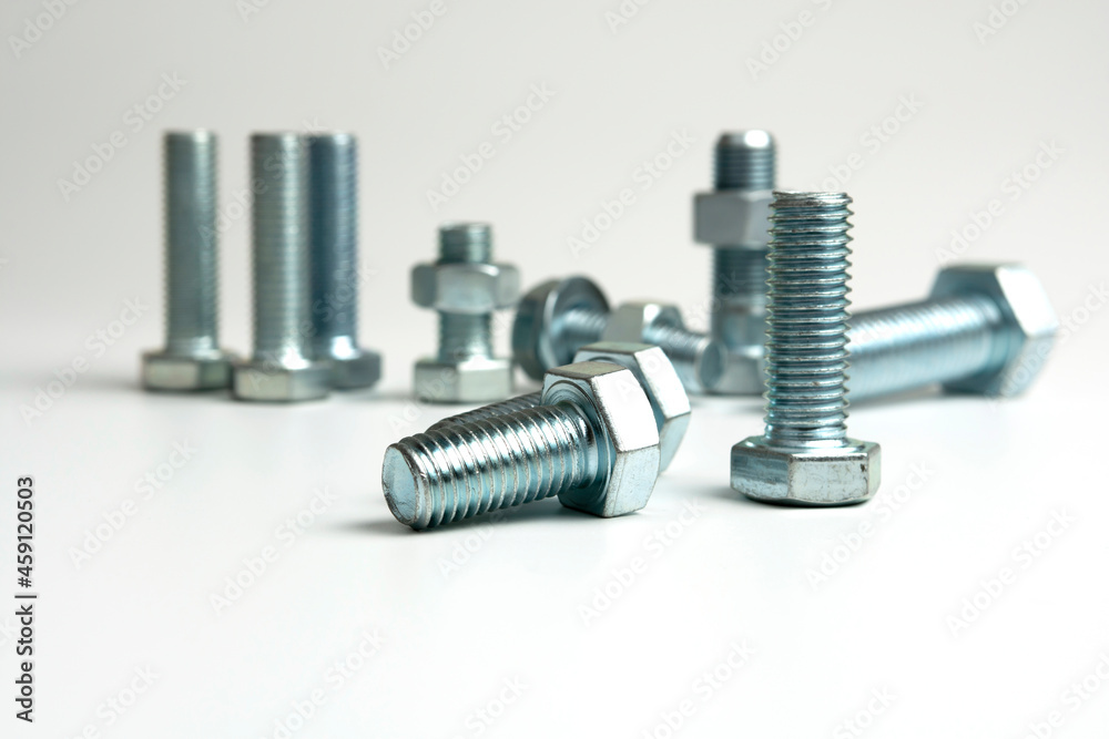 Several metal bolts and nuts on a white background Several metal bolts and nuts on a white background