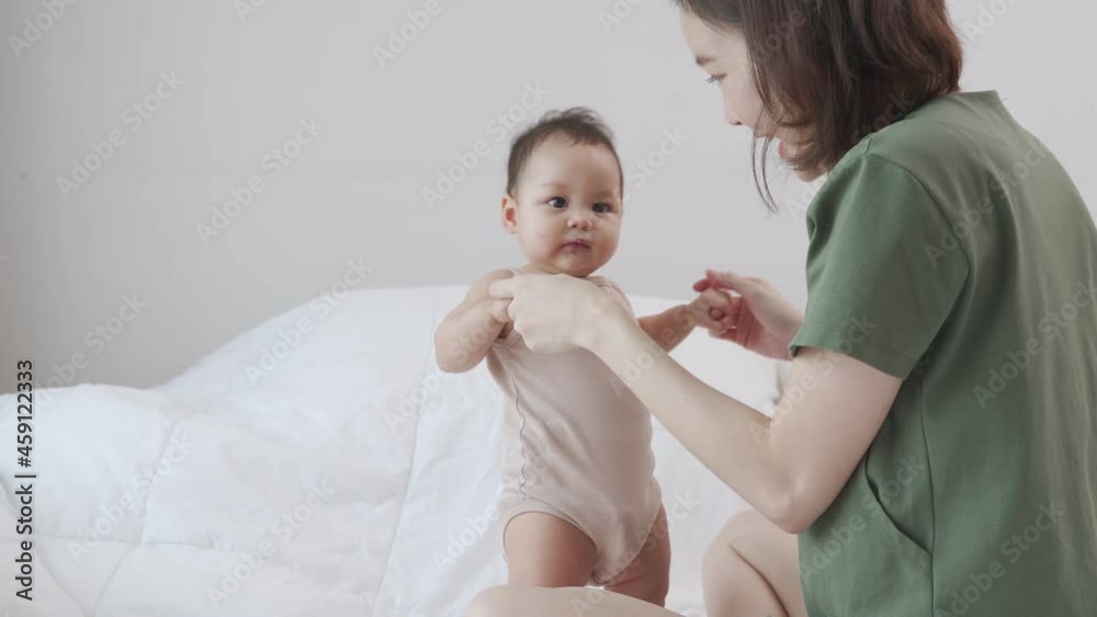 asian woman mother playing with baby infant toddler on bed in bedroom at home. innocence baby good relationship parent family. child smile happy when learning lesson from mom. asian woman mother playing with baby infant toddler on bed in bedroom at home. innocence baby good relationship parent family. child smile happy when learning lesson from mom.