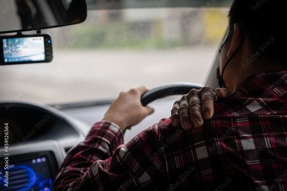 The young man had shoulder pain that was driving a long-distance car and gently massaged his right. The young man had shoulder pain that was driving a long-distance car and gently massaged his right.