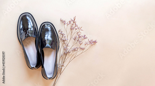 Fashionable minimalistic composition  women s black shoes with dried flowers. The arrival of autumn  fashion trends  wardrobe update concept