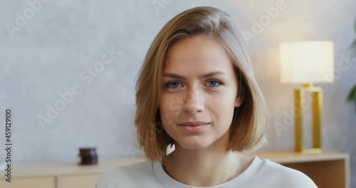 A young woman smiles a beautiful smile looking directly into camera