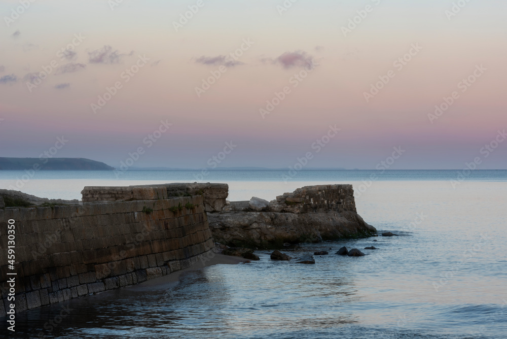 Beautiful vibrant late Summer sunset over Pentewan Sands on English Cornwall coast with long exposure motion blur of ocean Beautiful vibrant late Summer sunset over Pentewan Sands on English Cornwall coast with long exposure motion blur of ocean