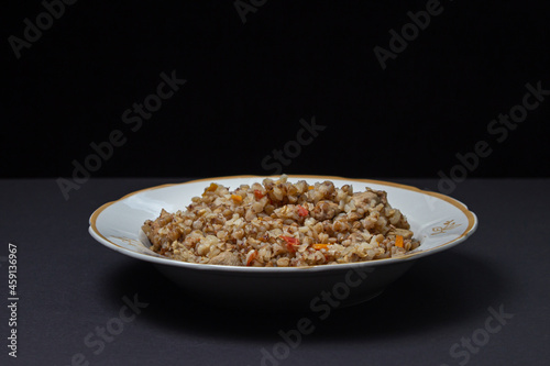 Buckwheat with meat on a black background. Delicious and healthy diet food