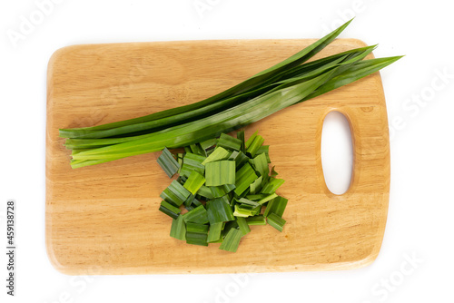 fresh green pandan leaves sliced in wooden chopping board isolated on white background
