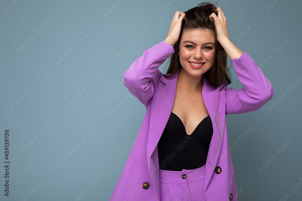 Young happy smiling brunette woman nice-looking attractive charming elegant fashionable wearing stylish suit with jacket isolated over blue background with copy space. Fun anf joy concept