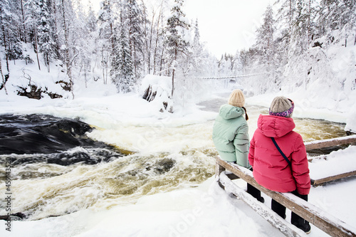 Mother and daughter enjoying winter landscape photo