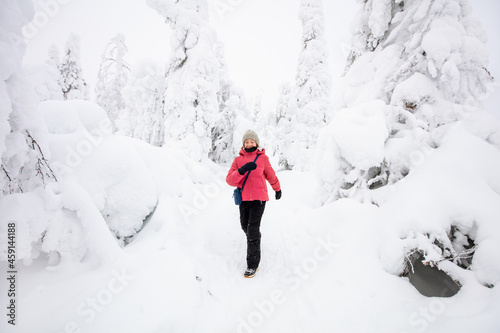 Cute girl in winter forest in Finland