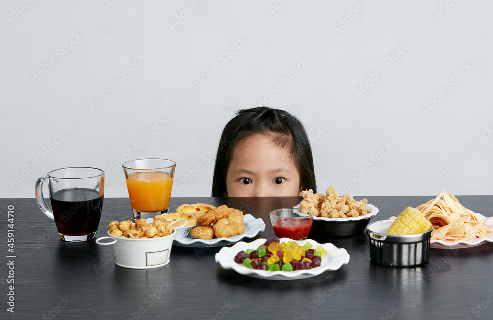Title: Asian little girl eating and playing indoors by herself Title: Asian little girl eating and playing indoors by herself