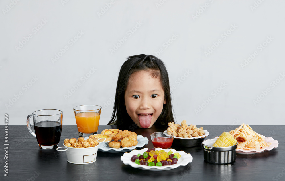 Title: Asian little girl eating and playing indoors by herself Title: Asian little girl eating and playing indoors by herself