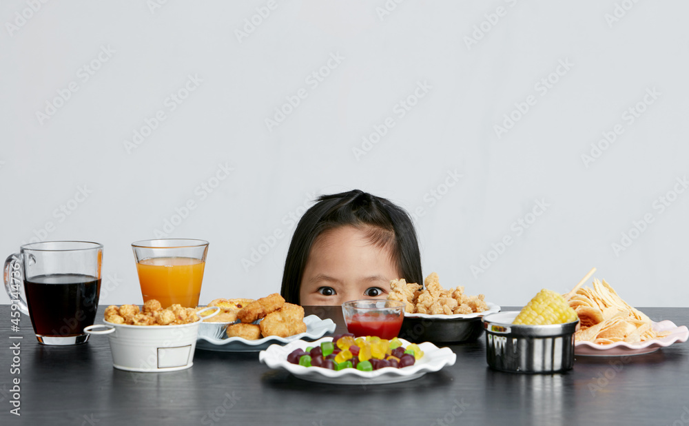Title: Asian little girl eating and playing indoors by herself Title: Asian little girl eating and playing indoors by herself