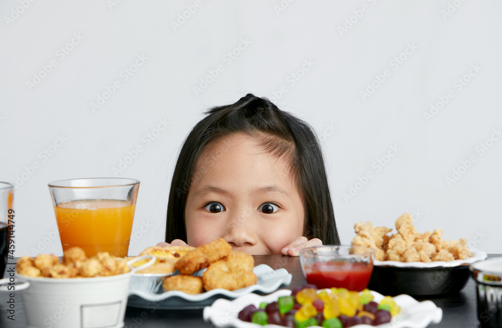 Title: Asian little girl eating and playing indoors by herself Title: Asian little girl eating and playing indoors by herself