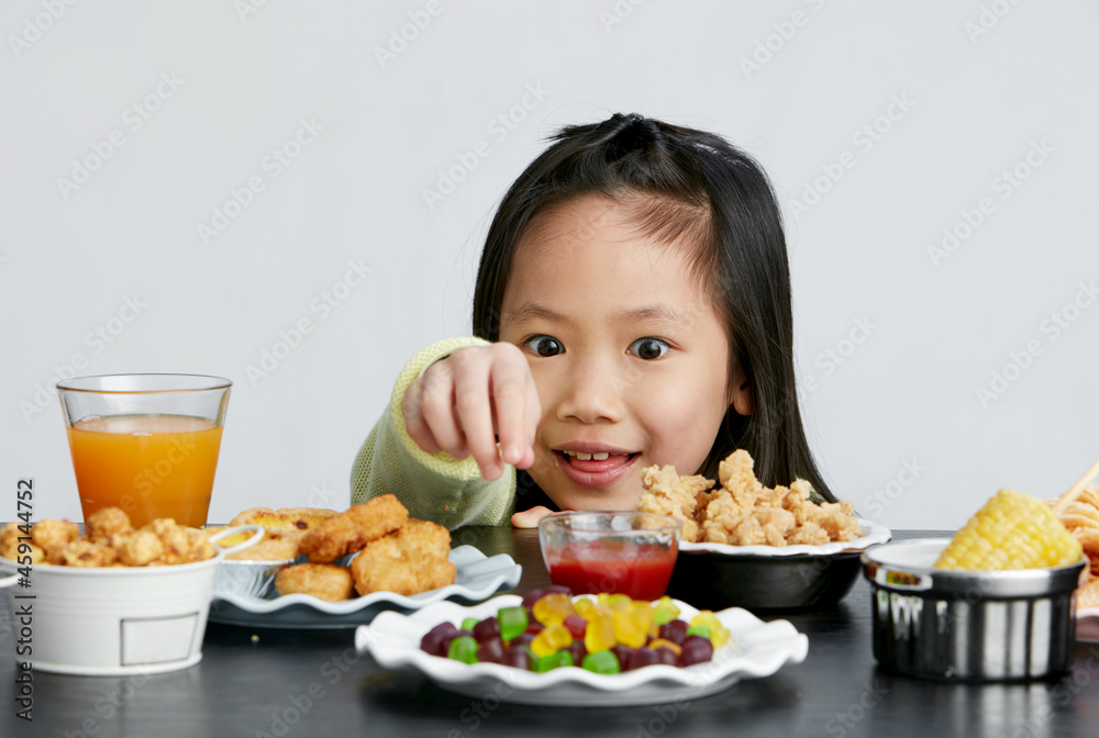 Title: Asian little girl eating and playing indoors by herself