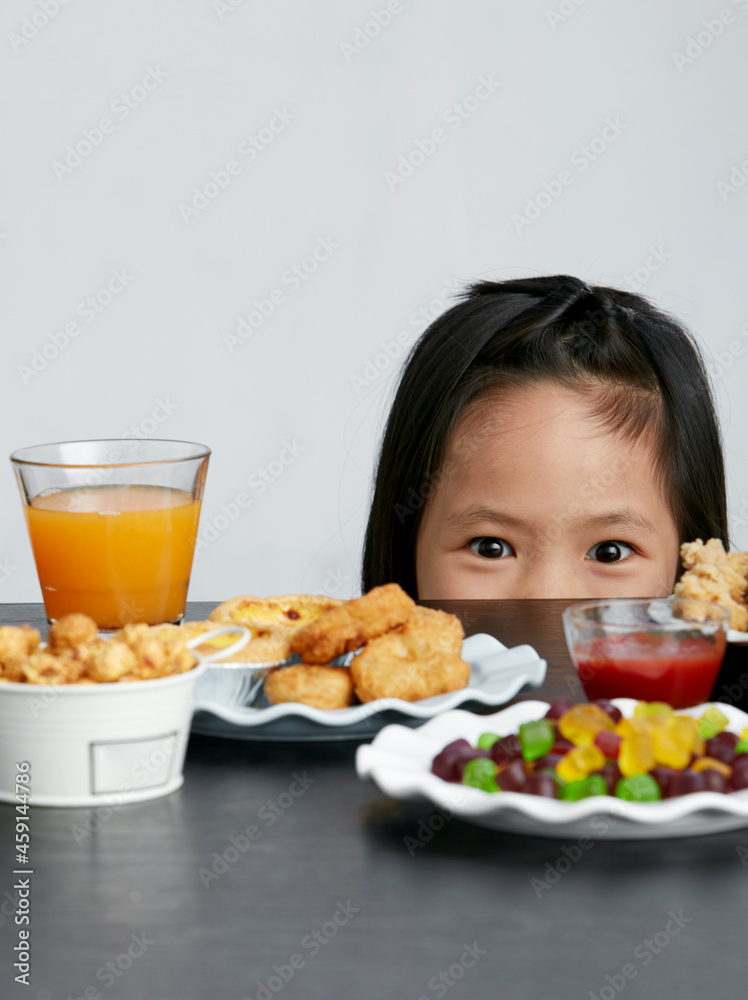 Asian little girl eating and playing indoors by herself Asian little girl eating and playing indoors by herself