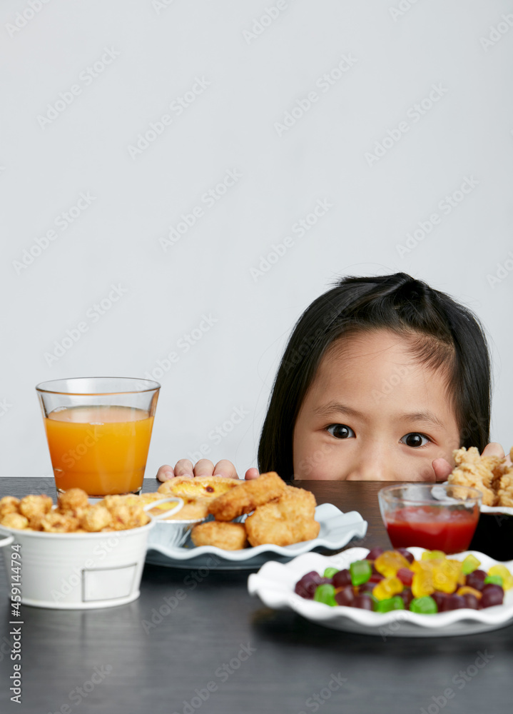 Asian little girl eating and playing indoors by herself Asian little girl eating and playing indoors by herself