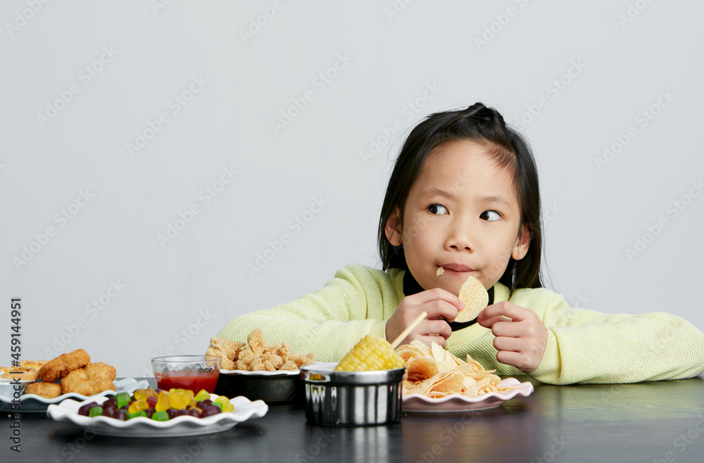 Asian little girl eating and playing indoors by herself Asian little girl eating and playing indoors by herself