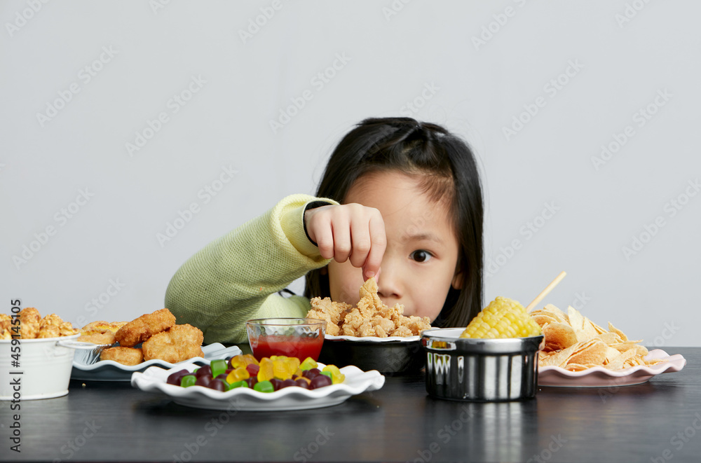 Asian little girl eating and playing indoors by herself Asian little girl eating and playing indoors by herself