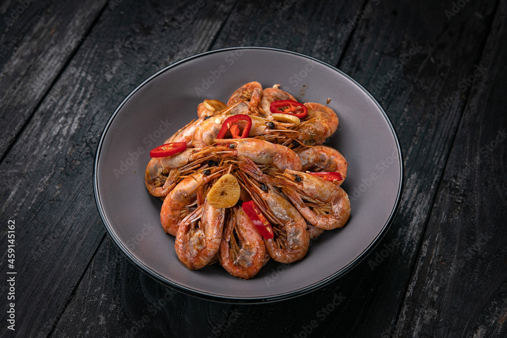 Seafood in a gray plate on a dark wooden table
Seafood in a gray plate on a dark wooden table