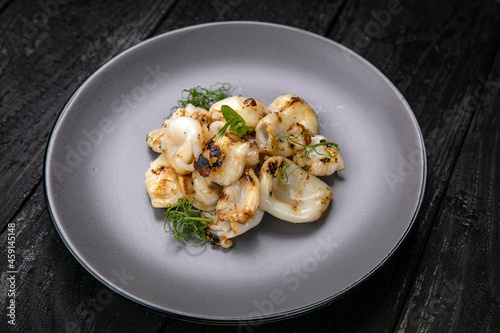 Seafood in a gray plate on a dark wooden table 