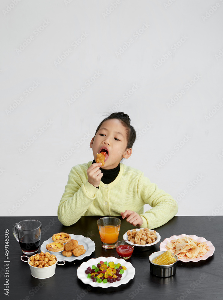 Asian little girl eating and playing indoors by herself Asian little girl eating and playing indoors by herself