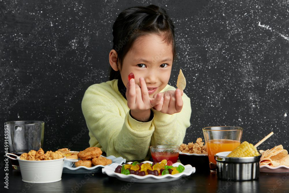 Asian little girl eating and playing indoors by herself Asian little girl eating and playing indoors by herself