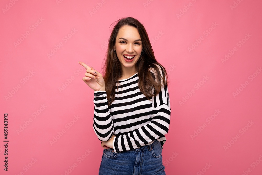 Portrait of beautiful fascinating emotional positive joyful happpy female promoter pointing to the side at copy space for advertising wearing hipster outfit isolated over background wall with empty Portrait of beautiful fascinating emotional positive joyful happpy female promoter pointing to the side at copy space for advertising wearing hipster outfit isolated over background wall with empty