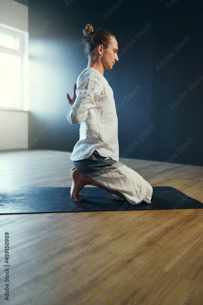Fototapeta premium Man doing paschima namaskarasana. Yoga practice in the studio.