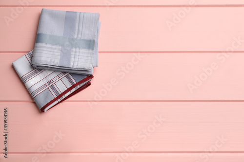 Different handkerchiefs folded on pink wooden table, flat lay. Space for text