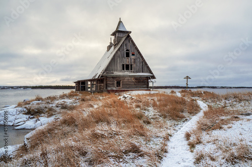 Snowy winter landscape with authentic cinematic house on the shore in the Russian village Rabocheostrovsk photo