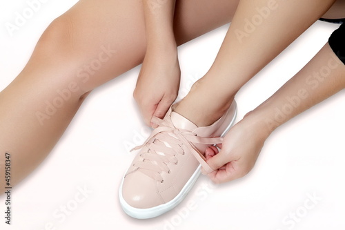 female hands tying sneaker