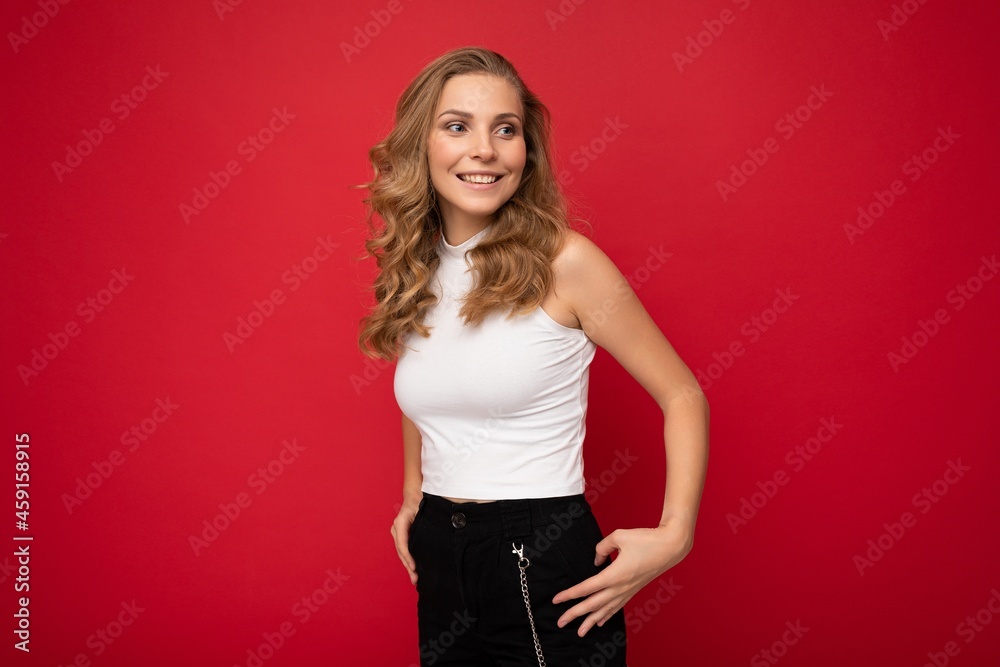 Photo portrait of young beautiful attractive positive smiling blonde woman wearing white top isolated over red background with copy space