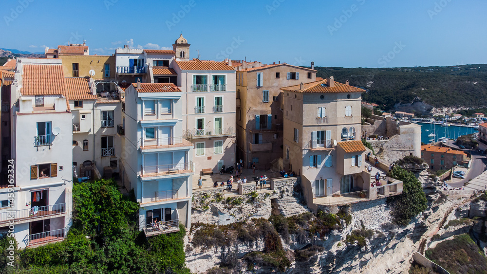 Aerial view of old houses built on the edge of the cliffs of Bonifacio overlooking the Mediterranean Sea in the south of the island of Corsica, France