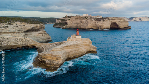 Aerial view of the lighthouse of La Madonetta in Bonifacio, at the southern tip of the island of Corsica in France - Waves crashing on limestone cliffs in the Mediterranean Sea