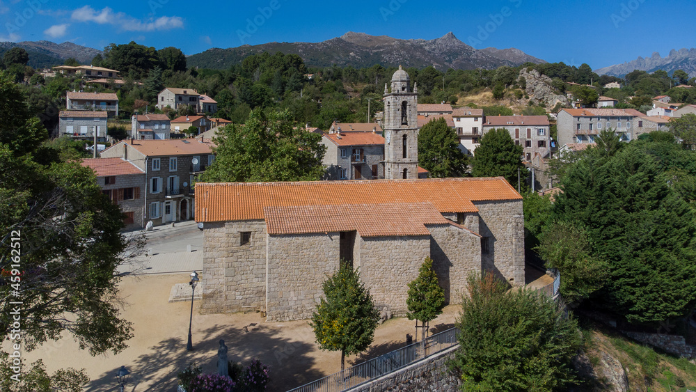 Aerial view of the mountainous village of Quenza in the Alta Rocca region of the South of Corsica, France - St. George's Church in front of the famous Bavella Peaks